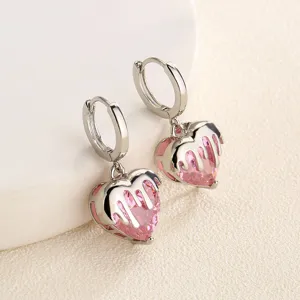 Close-up detail van zoet-coole roze hart zirkoon oorringen met uniek smeltontwerp.