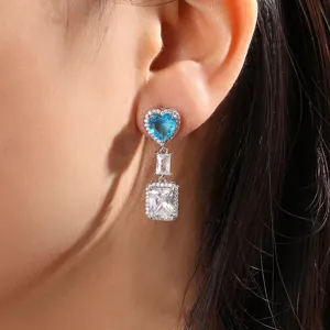 Gedetailleerde close-up van elegante lange oorbellen met blauwe hartsteen en zirkonia.