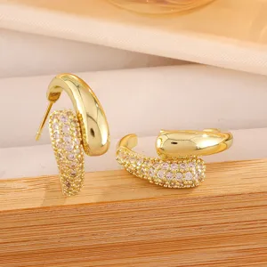Gedetailleerd overzicht van gouden C-vormige oorbellen met zirkonia, elegant slangdesign sieraad.