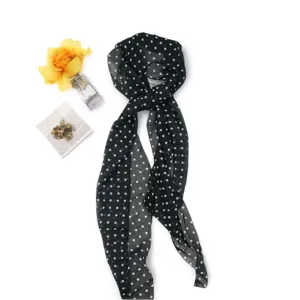 Close-up detail view of the elegant black and white polka dot chiffon scarf, perfect for styling.