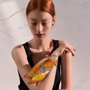 Stylish orange skinny silk scarf detail view, elegant zebra print ribbon for bags and wrists.