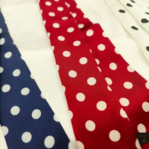 Close-up detail of vintage polka dot silk ribbon scarf, colorful hairband and bag accessory.