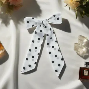 Elegant black and white polka dot silk ribbon hair bow, stylish versatile decorative accessory.