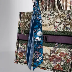 Close-up detail of luxury embroidered canvas tote bag with floral print silk twill scarf ribbon.