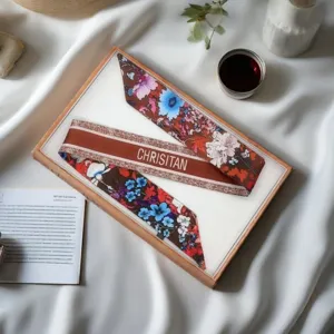Detailed view of floral silk twill ribbon scarf in retro brown, elegant bag tie and gift accessory.