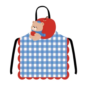 Detailansicht der süßen blauen Karo-Schürze mit Cartoon-Bär und rotem Apfel-Design.