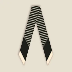 Close-up detail of a classic black and white striped skinny silk scarf for elegant styling.