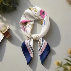 Close-up view of a retro floral silk square scarf featuring elegant pink blooms and stylish blue border.