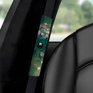 Detailansicht des Autogurtkissens mit Ölgemälde Seerosen Design und süßem schwarzen Katzenmuster.