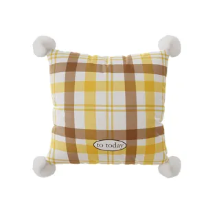 Detailed view of French retro plaid pillow cover with white pom poms and text accent.