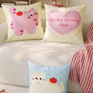 Detail view of cute cartoon cat decorative throw pillows on a cozy cream sofa setup.