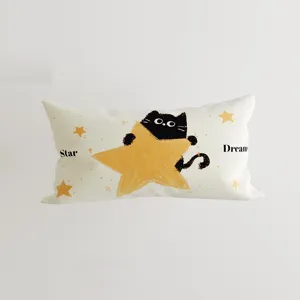 Vista dettagliata del cuscino con gatto nero in stile cartone animato con stampa stella.