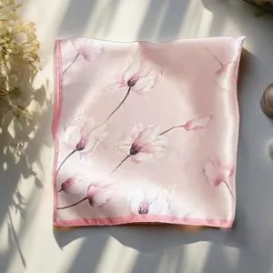 Pink floral silk scarf detail view, elegant tulip print accessory, soft fabric texture close-up.