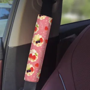Pink dessert car seatbelt shoulder pad cover detail view, cute strawberry illustration interior accessory.