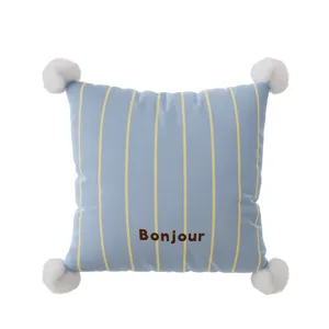 Federa per cuscino a righe blu con pon pon bianchi e stampa Bonjour per divano accogliente.