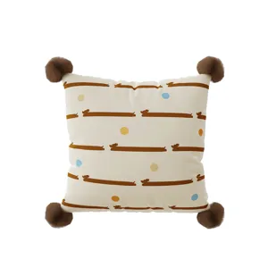 Close-up of square throw pillow with cute dachshund pattern and corner pom-poms decor.