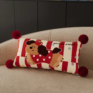 Gros plan sur le joli coussin rectangulaire de chien de dessin animé avec pompons rouges.