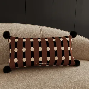 Retro polka dots lumbar pillow with black stripes and pom-poms for cozy sofa home decor.