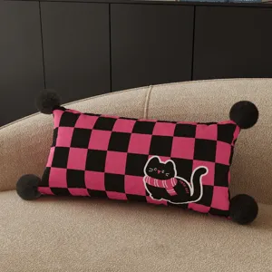 Pink and black checkered lumbar pillow detail, featuring a cute cat graphic and fluffy pom poms.