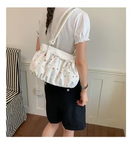 Vue détaillée du sac porté épaule blanc à pois colorés, accessoire chic pour le quotidien.