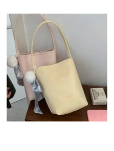 Summer minimalist bucket bag with plush ball charm, stylish leather shoulder bag for women.