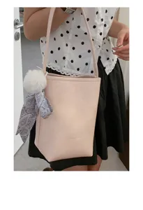 Minimalist pink bucket bag for women, stylish shoulder tote with cute pom-pom charm.