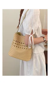 Geflochtene Beuteltasche Detailansicht mit Lochmuster, Strohdesign und Schultergurt.