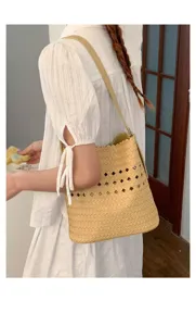 Nahaufnahme der gewebten Damen Schultertasche im Eimer Stil in Hellkhaki mit eleganten Ausschnitten.