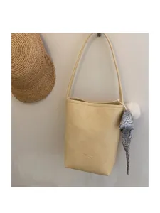 Minimalist beige leather bucket bag for women, chic single shoulder underarm handbag daily use.