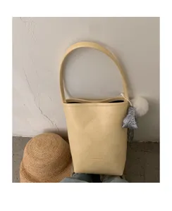 Exquisite detail of the minimalist yellow leather bucket bag showing texture and cute charm.