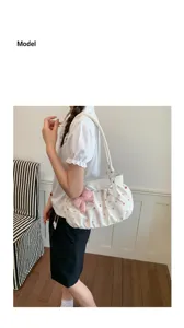 Vue détaillée d'un joli sac à épaule blanc avec des pois colorés, un nœud et des perles.