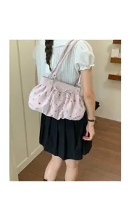 Vue détaillée du sac sous-bras plissé rose avec des pois colorés et un nœud mignon.