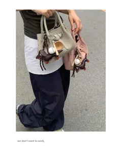 Detail view of the minimalist canvas handbag with cute puppy keychain charm and top handles.