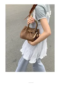 Brown textured small handbag for women, chic tote bag with belt buckle and cute charms.