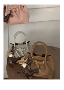 Minimalist leather handbag with cute charm detail, stylish daily tote bag for women.