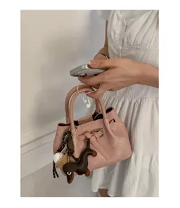 Minimalist pink handbag with chic strap detail and cute charms, elegant daily tote bag.
