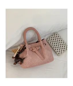 Close-up view of the chic pink textured mini handbag showing exquisite buckle detail and charms.