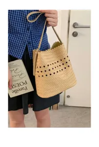 Detailansicht einer beige geflochtenen Tasche mit Ausschnitt, lässig über der Schulter getragen.