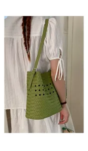 Grüne geflochtene Leder Eimer Tasche Detailansicht mit feinem Lochmuster und Gurt.