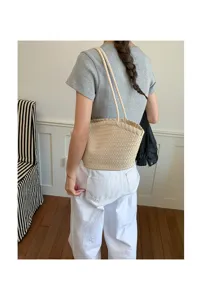 Vista dettagliata dell'elegante borsa a spalla intrecciata beige, comoda borsa chic.