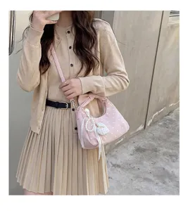 Pink polka dot crescent shoulder bag for women, stylish handbag with elegant pearl pendant.