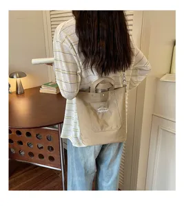 Vue détaillée du sac-seau décontracté en toile avec poche avant dans un intérieur chaleureux.
