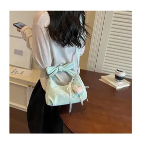 Chic light green polka dot shoulder bag with stylish bow and heart pendant for women.