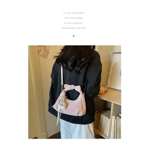 Close-up detail of the pink polka dot crescent shoulder bag with bow handle and pearl heart.