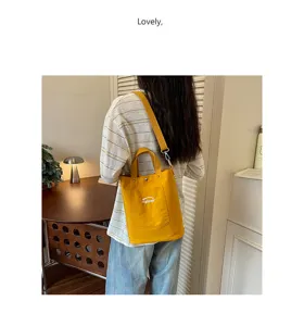 Vue détaillée du sac seau en toile jaune décontracté avec bandoulière et poche avant.