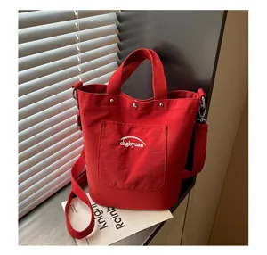 Détail en gros plan de la poche et de la bandoulière du sac seau en toile rouge, style.