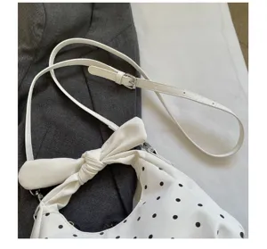 Stylish white polka dot shoulder crossbody hobo bag with cute bow and adjustable strap.