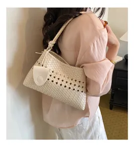 Detailed shot of stylish woven underarm bag showcasing unique hollow design and exquisite texture.