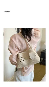 Detailed view of women woven leather underarm shoulder bag in beige with chic knot handle.