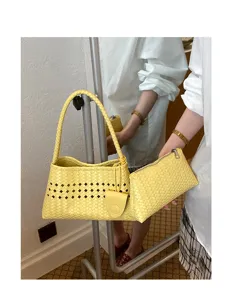Yellow woven leather underarm bag for women, stylish hobo handbag with cutouts and pouch.